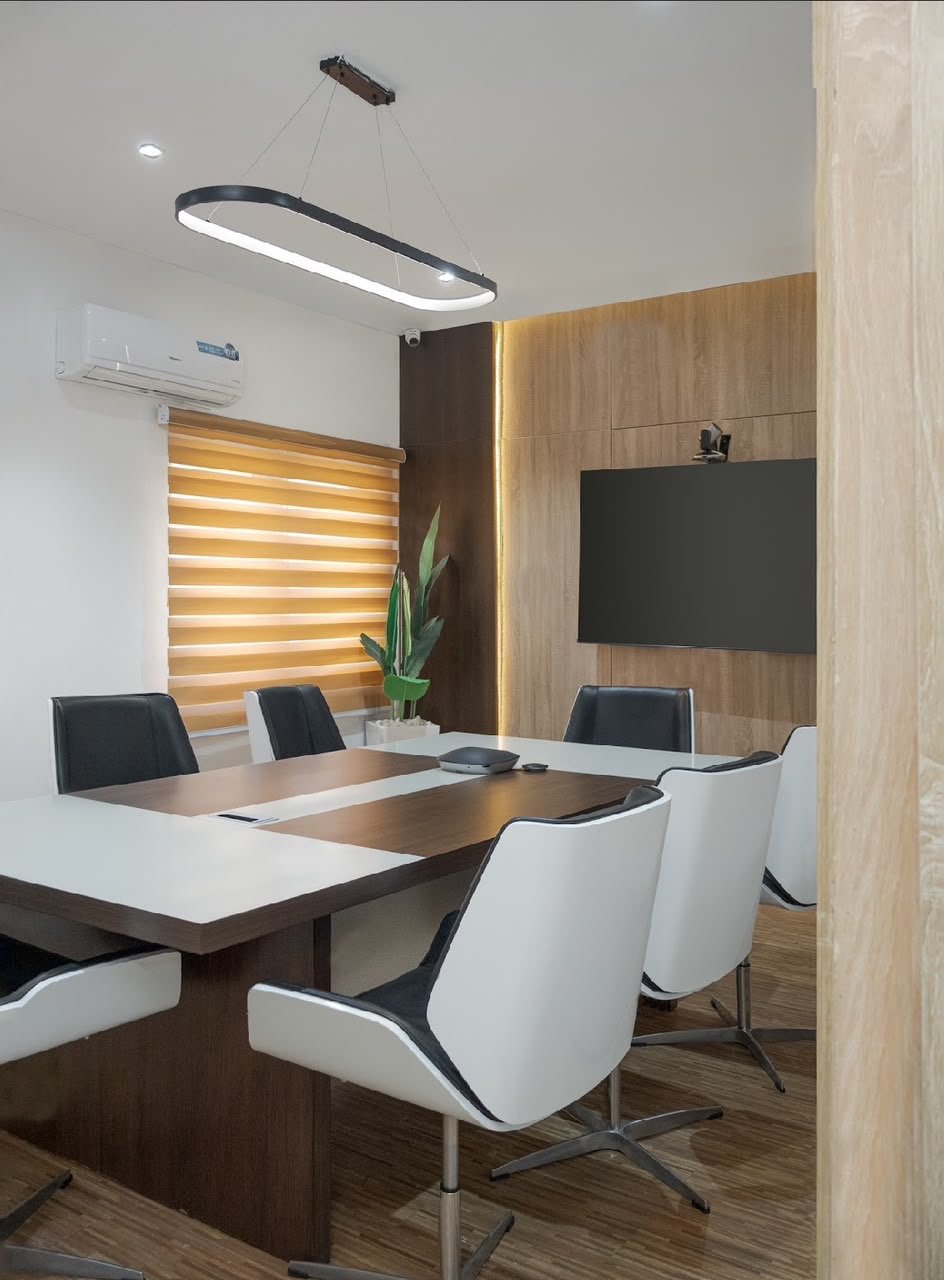 Conference room with oval pendant light and black and white chairs