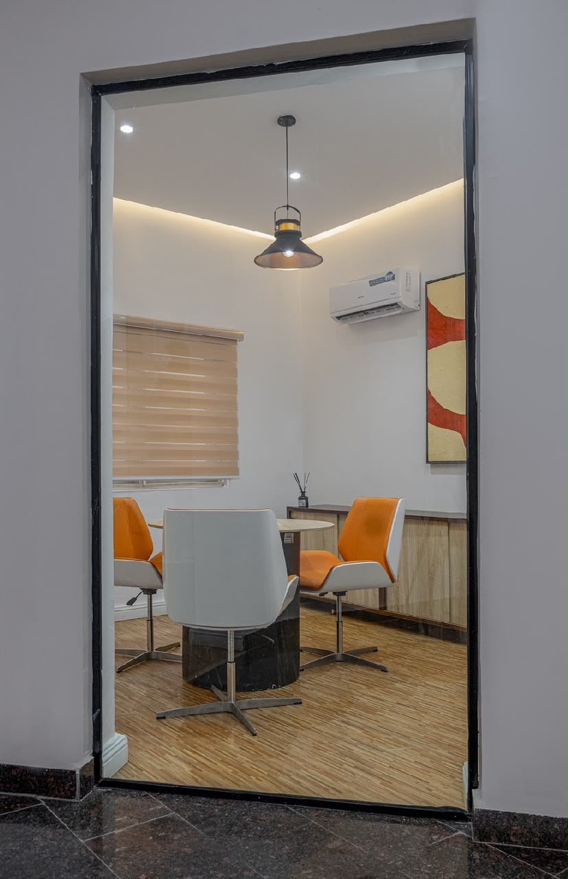 Executive lounge nook with orange chairs and round table